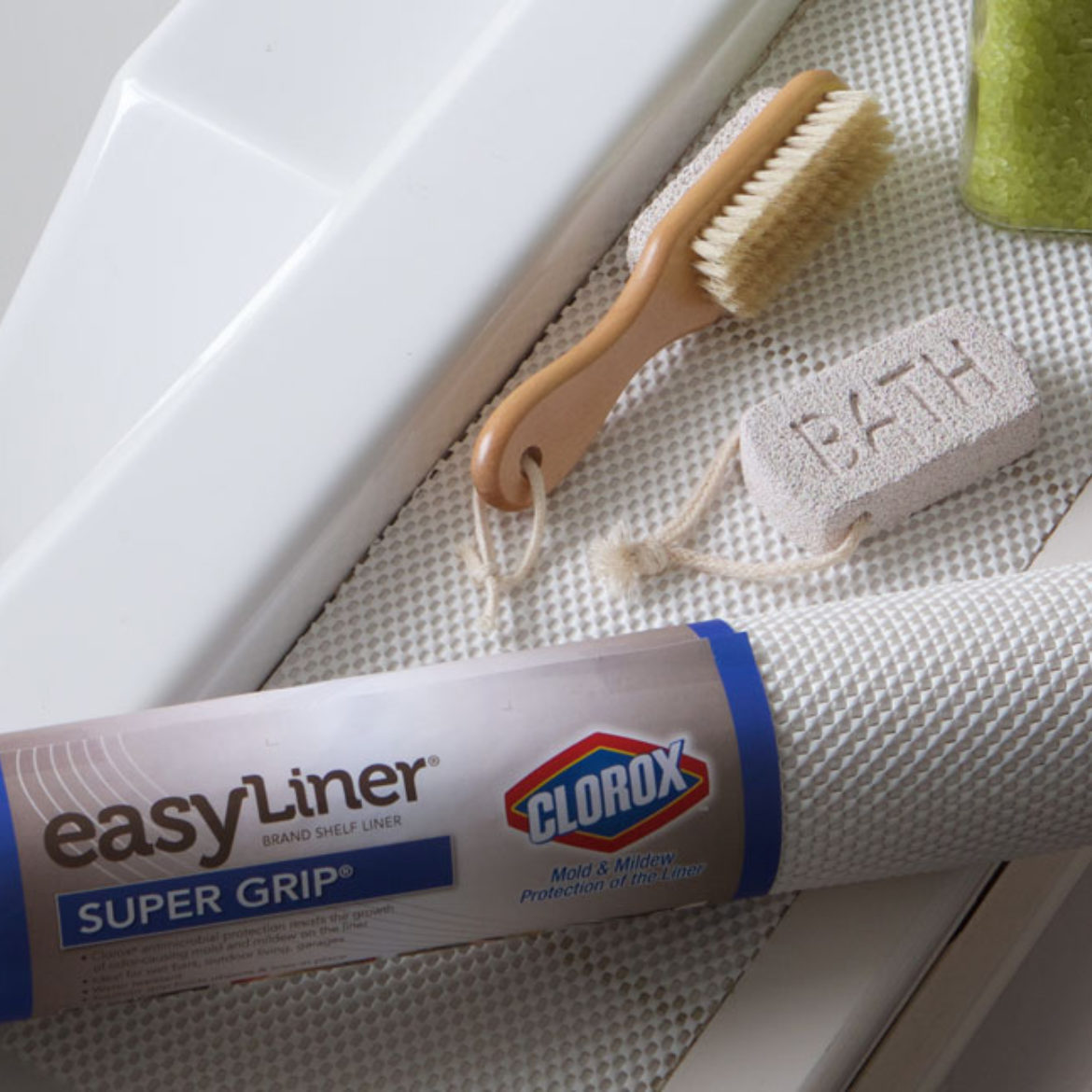 A roll of shelf liner surrounded by bath accessories. 