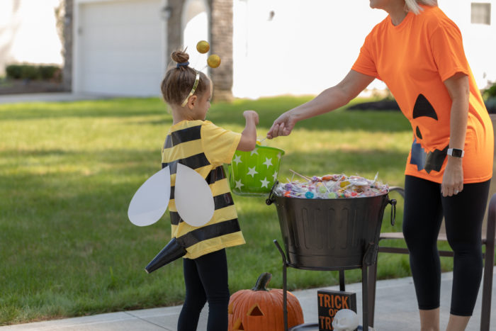 A child in a bumblebee costume getting candy