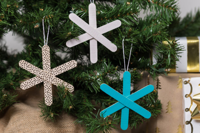 Three snowflake ornaments made from popsicle sticks and Duck Tape