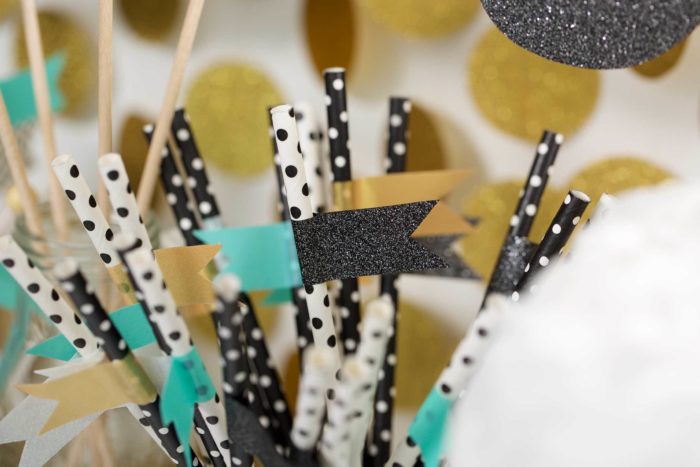 A cup full of straws decorated with washi tape.