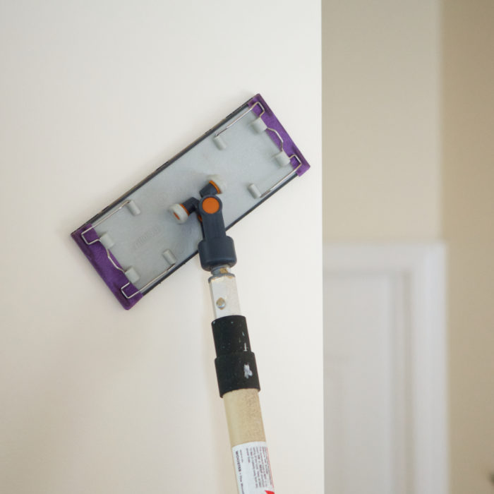 Sanding a wall before painting.