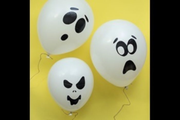 Three white balloons with ghosts faces on them