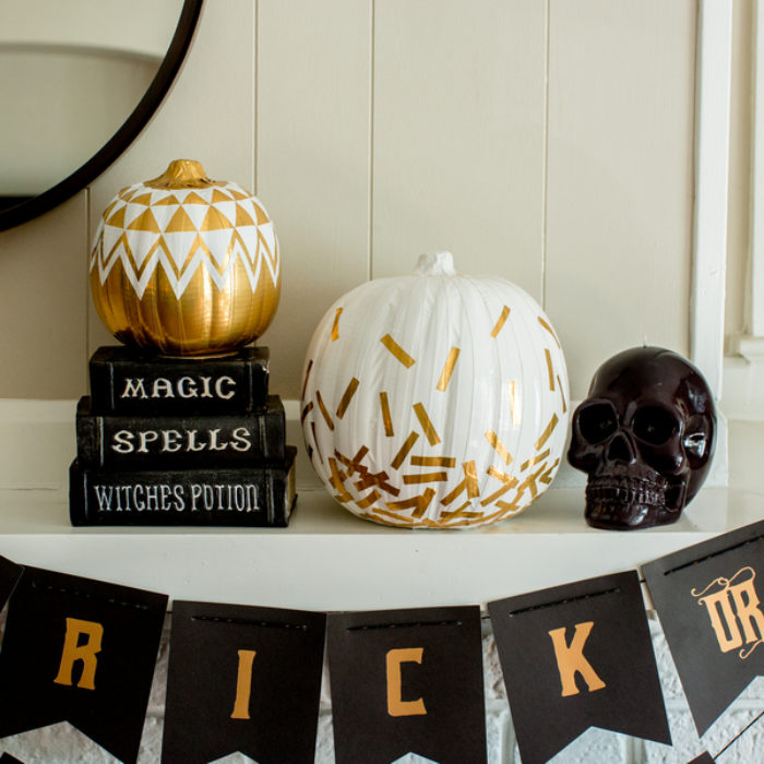 A white pumpkin decorated with gold pieces of Duck Tape in a confetti pattern