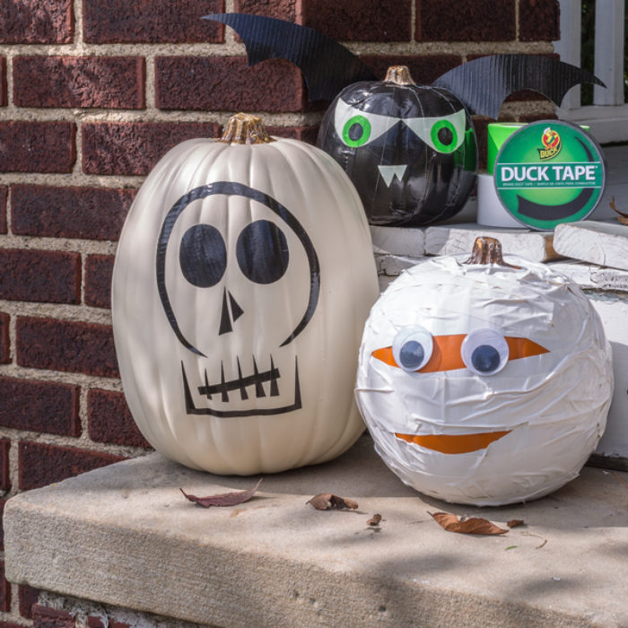 Two plastic pumpkins decorated as a skeleton and a mummy.