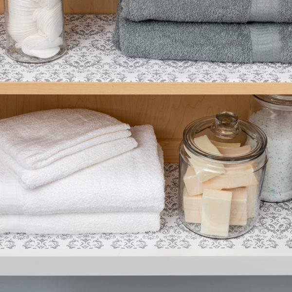 Gray Damask Smooth Top liner in bathroom shelves with towels and soap on top