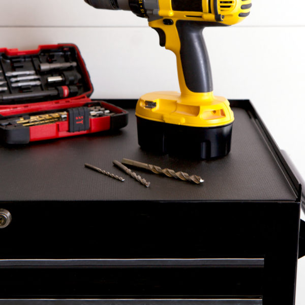 Drill and some screws on top of Supreme Grip on a tool box