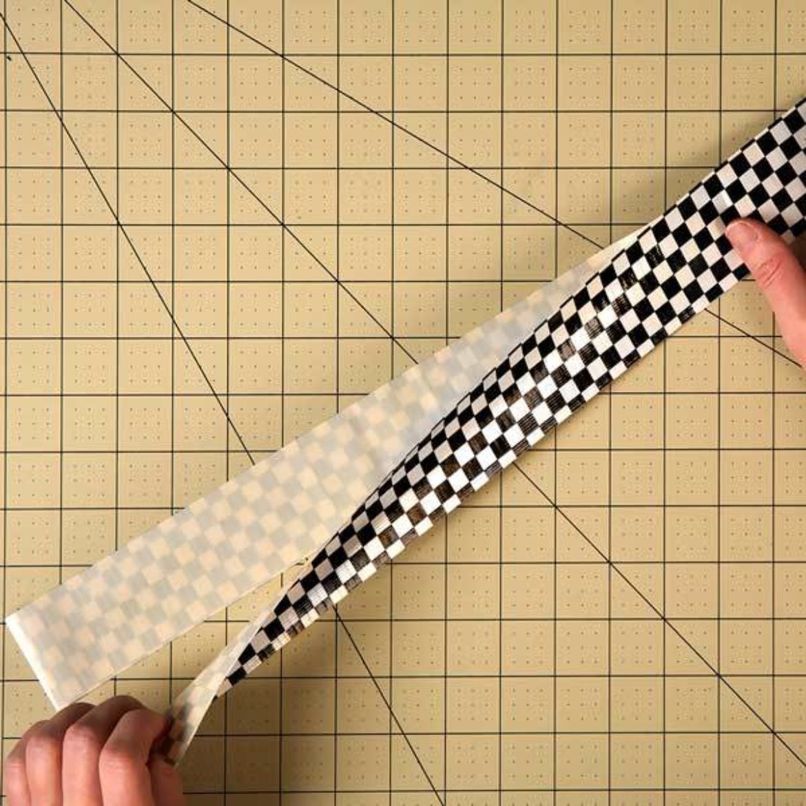 Two strips of tape laid together so that it forms a double sided strip