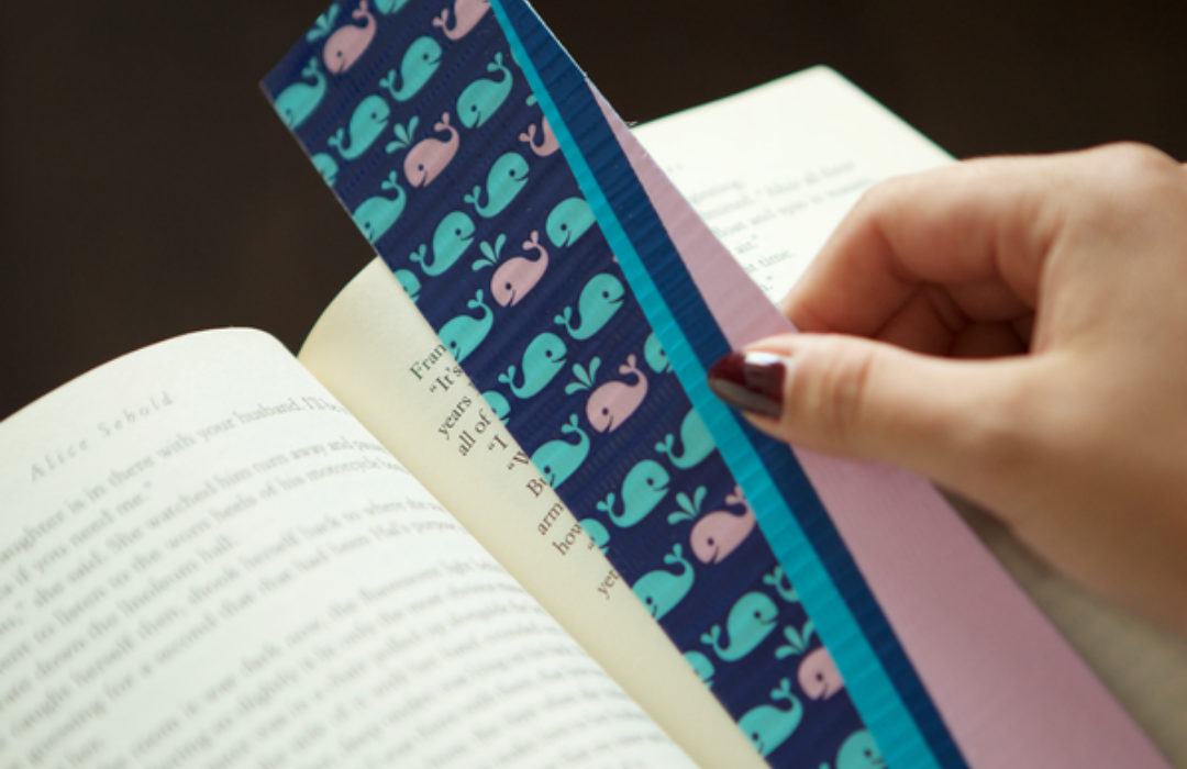 Completed Duck Tape® Bookmark being placed in a book