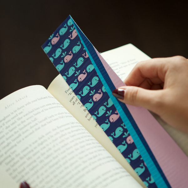 Completed Duck Tape® Bookmark being placed in a book