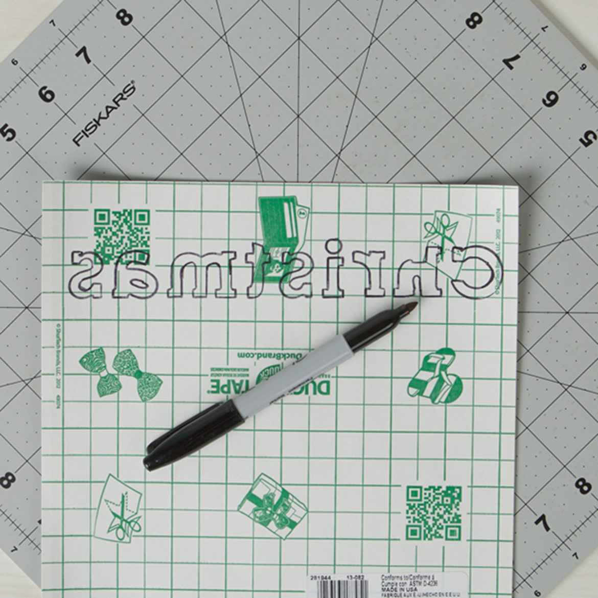 Christmas written backwards on the back side of a Duck Tape Sheet with a permanent marker