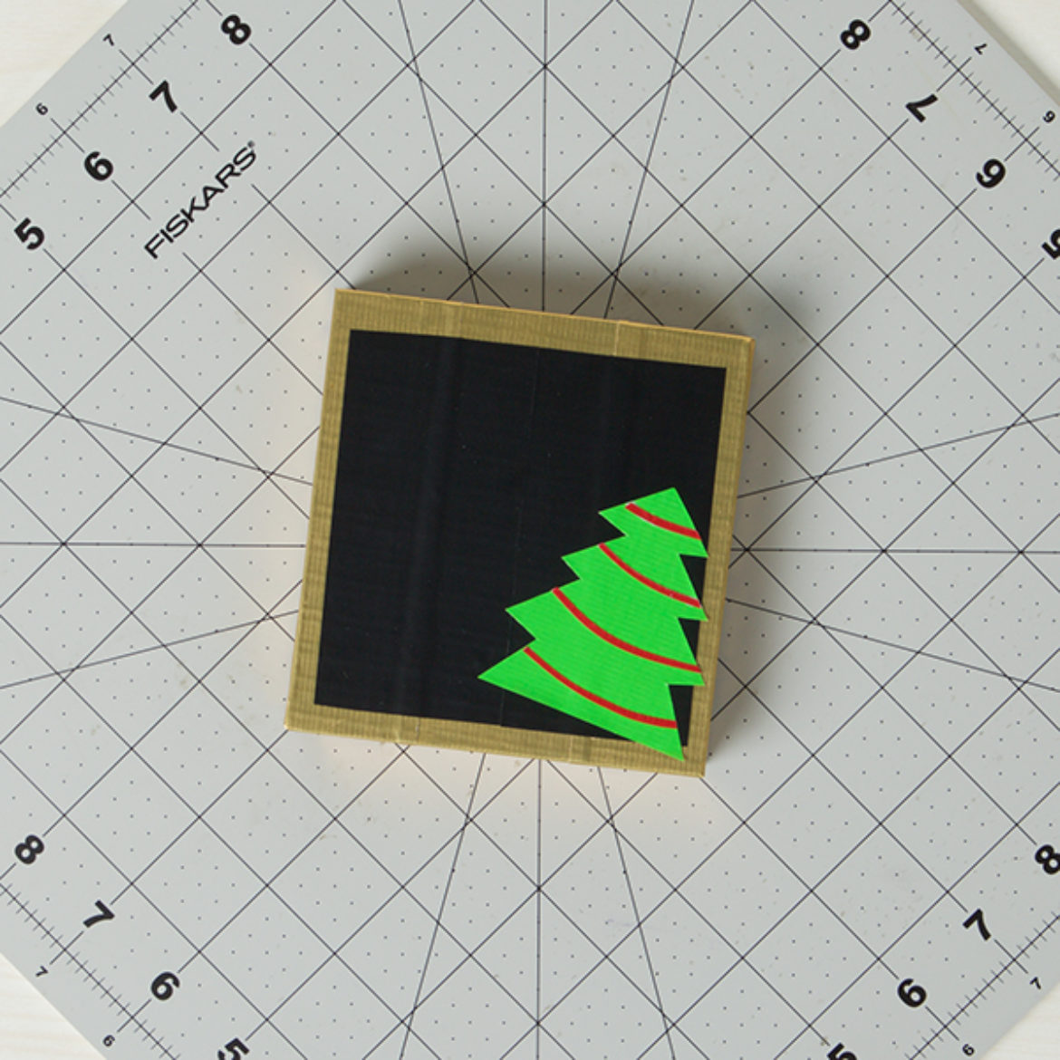 Duck Tape Christmas tree cutout pasted in the corner of the chalk board block