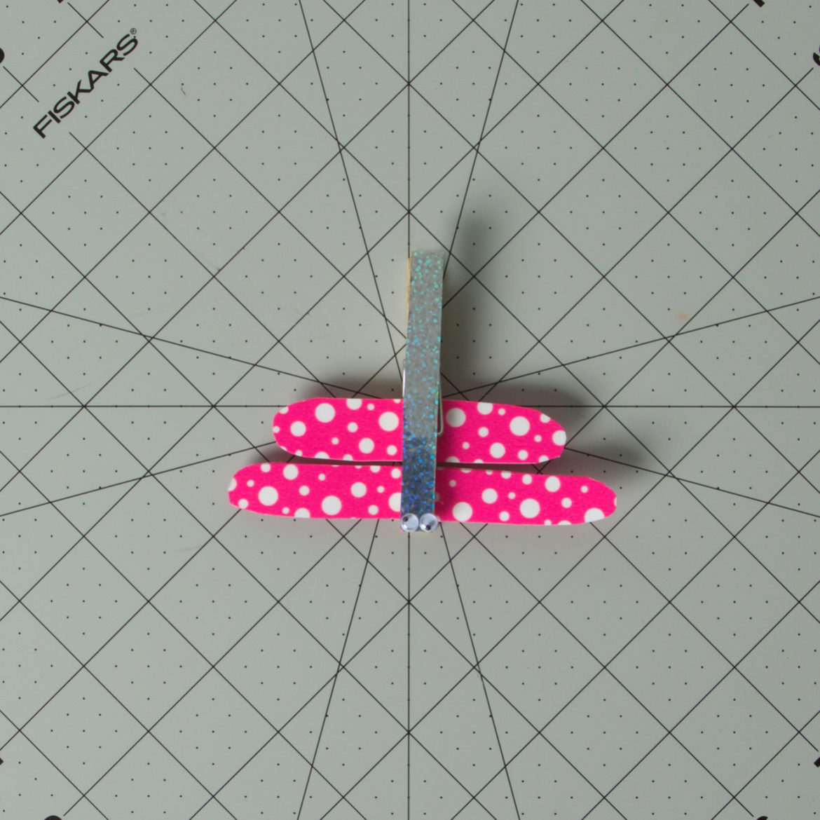 googly eyes added to the clothes pin to complete the dragonfly