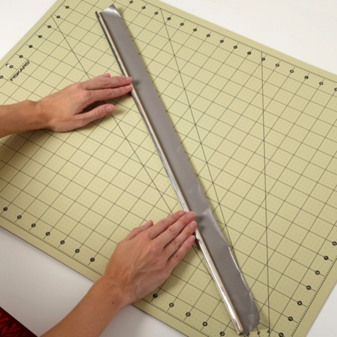 Dowel rod being wrapped in Duck Tape