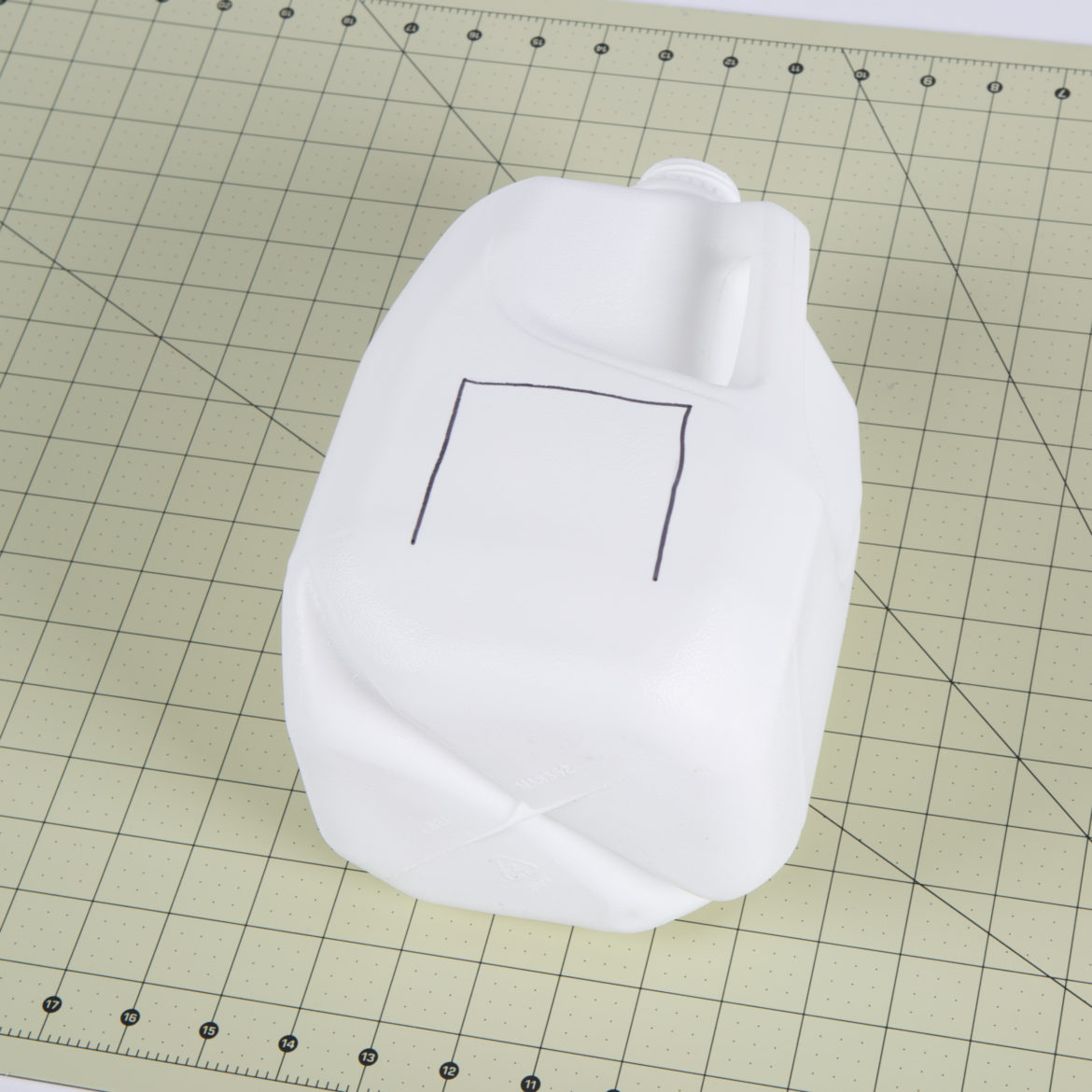 Upside down U shape drawn on the side of the jug to form a flap