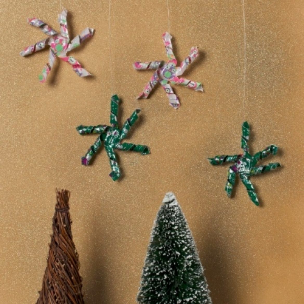 Completed Duck Tape® Hanging Snowflakes hanging on a wall above trees