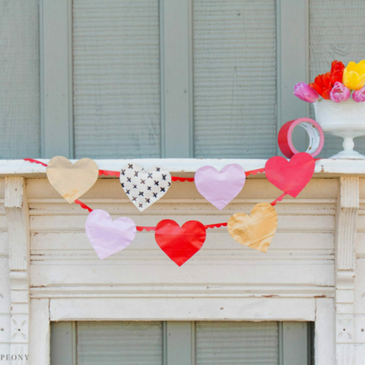 Heart garland handing over a fireplace mantle with 7 hearts of various colors and prints