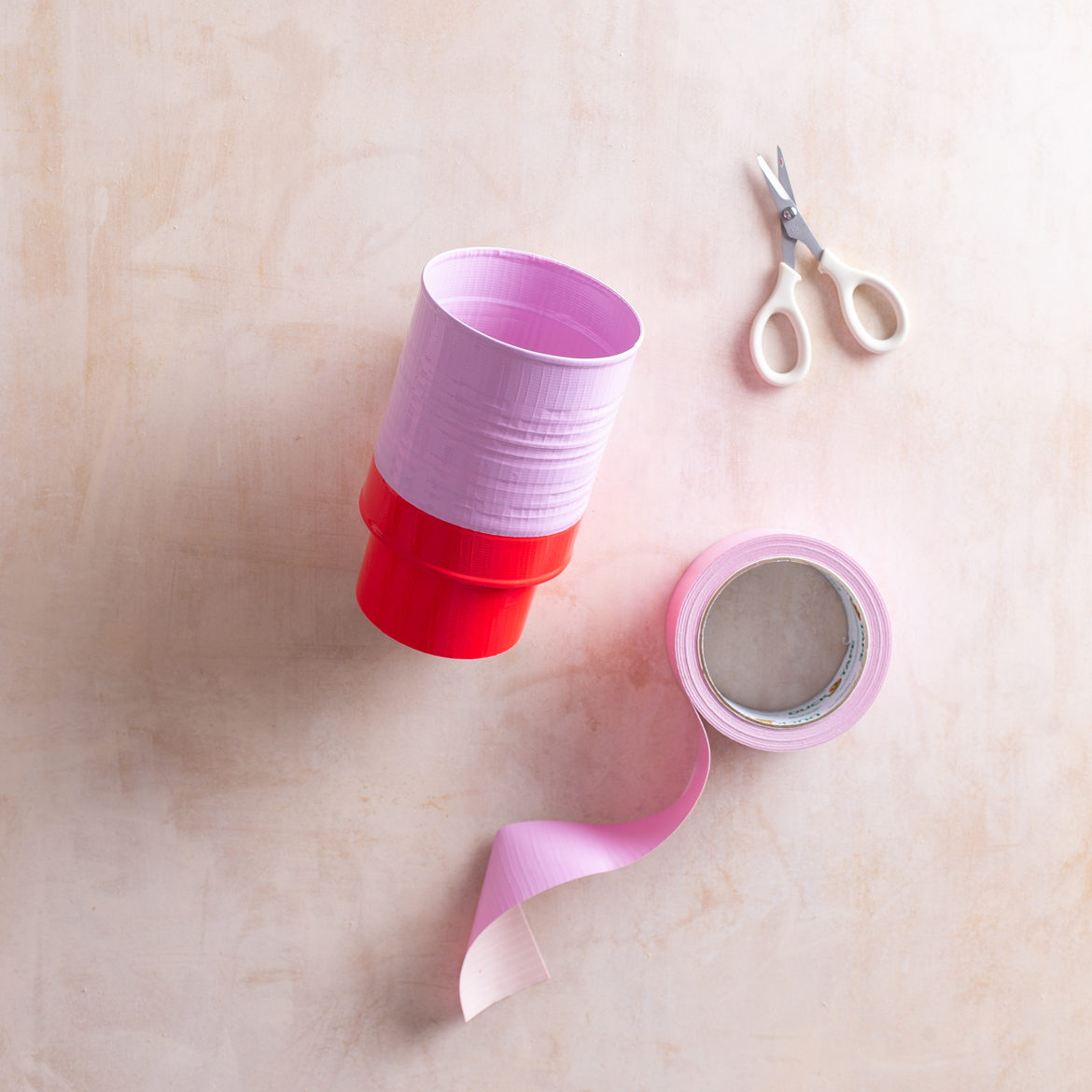 Empty can shown with tape roll at bottom but with purple colored tape around ¾ of can + purple tape and scissors