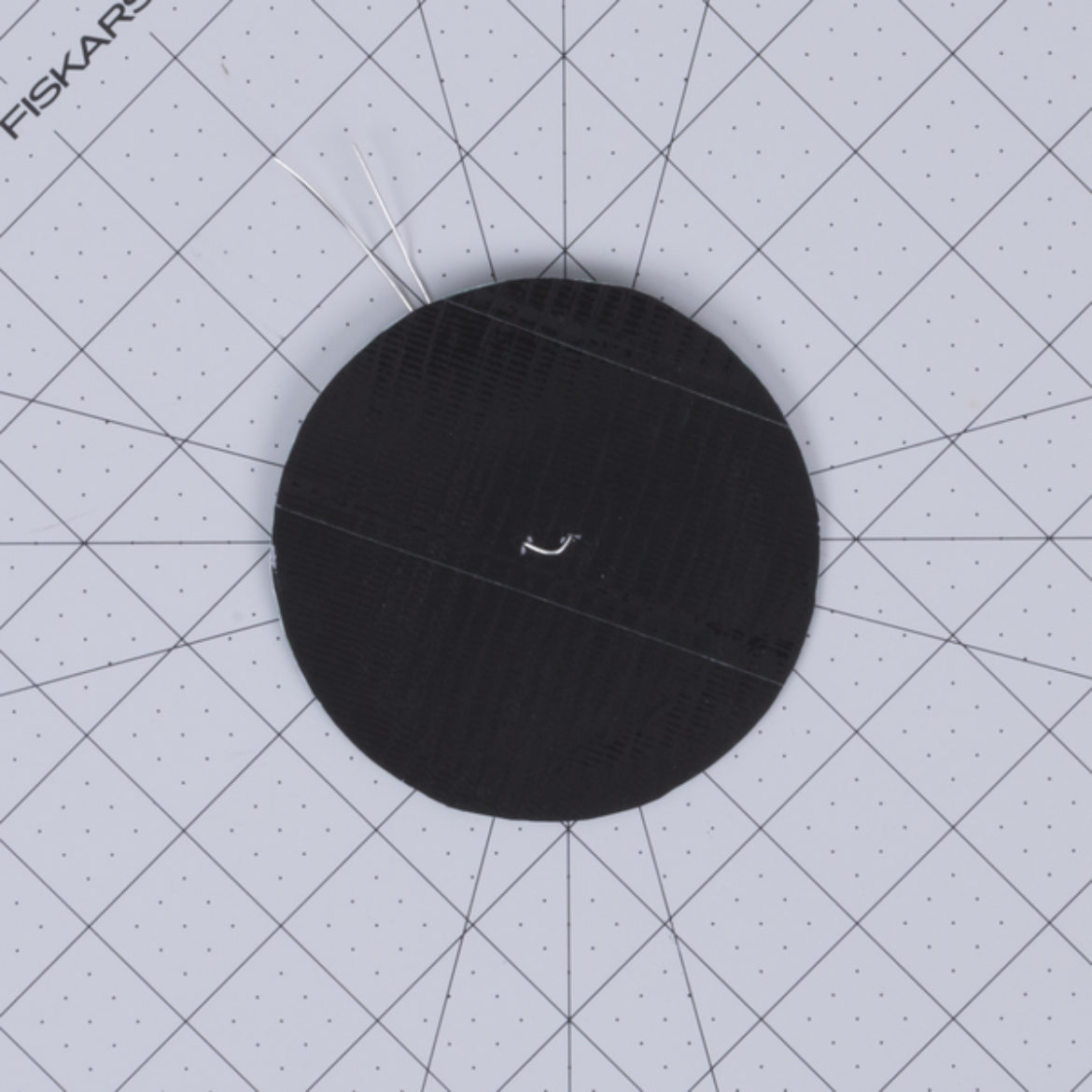 Duck Tape core wrapped in black Duck Tape with a wire looped through the center