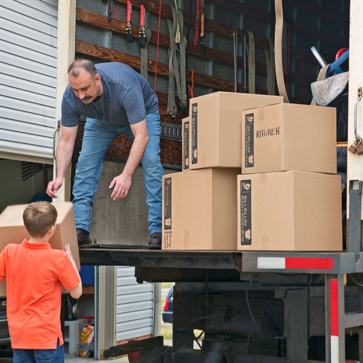 People loading boxes into a moving truck.